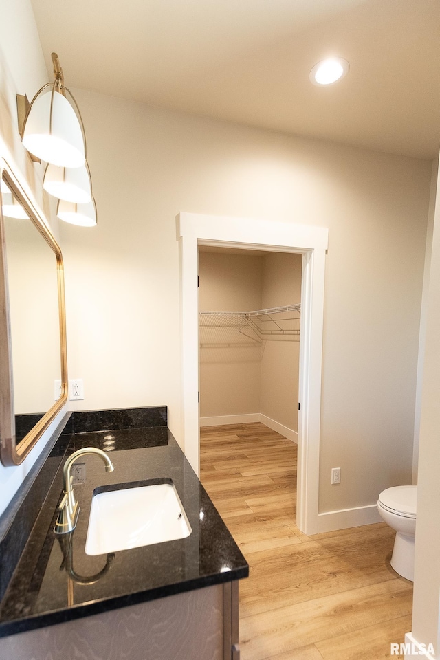 bathroom featuring vanity, hardwood / wood-style floors, and toilet