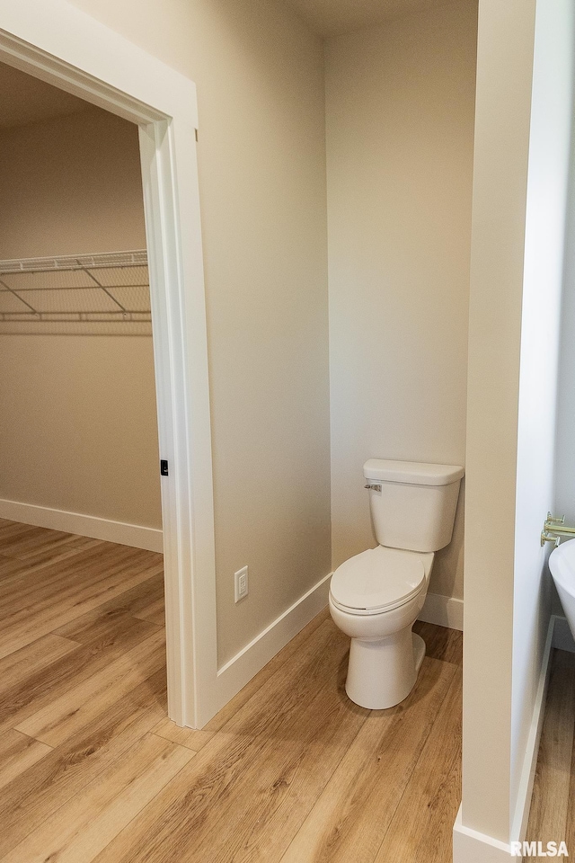 bathroom featuring wood-type flooring and toilet