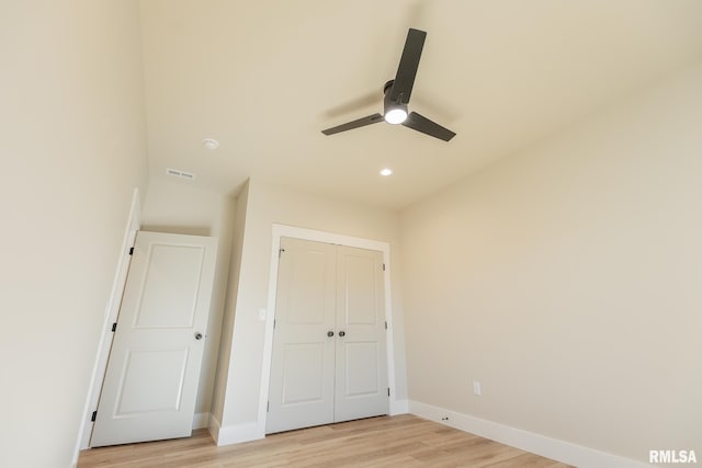 unfurnished bedroom featuring ceiling fan, light hardwood / wood-style floors, and a closet