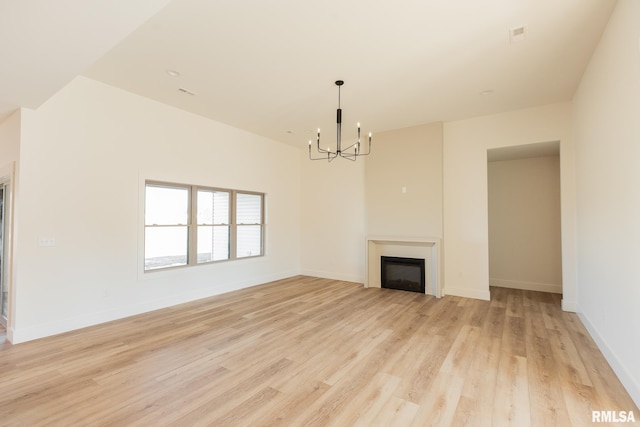 unfurnished living room featuring light hardwood / wood-style floors and a notable chandelier