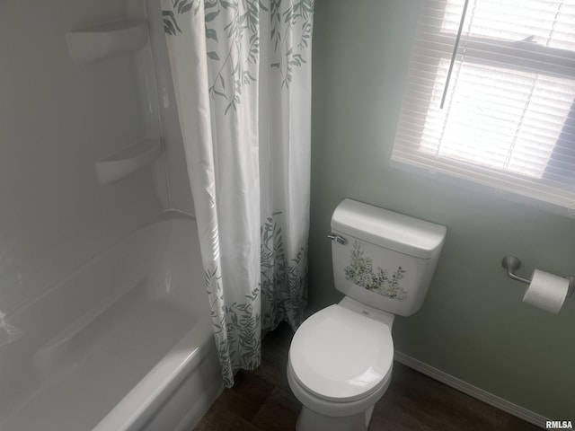 bathroom with hardwood / wood-style floors, shower / bath combo, and toilet