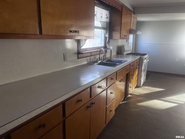 kitchen with white range with gas stovetop, sink, and extractor fan