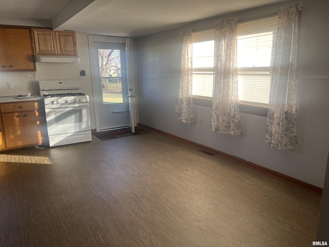 kitchen featuring white range with gas stovetop and dark wood-type flooring