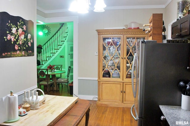 dining room featuring crown molding, a notable chandelier, and light wood-type flooring