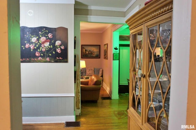 corridor with hardwood / wood-style floors and crown molding