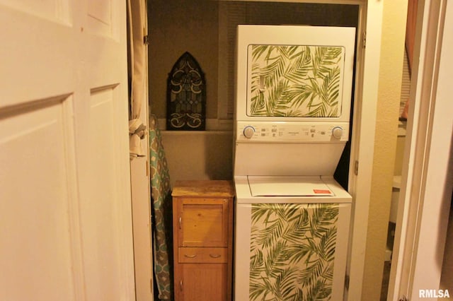 clothes washing area featuring stacked washer and clothes dryer