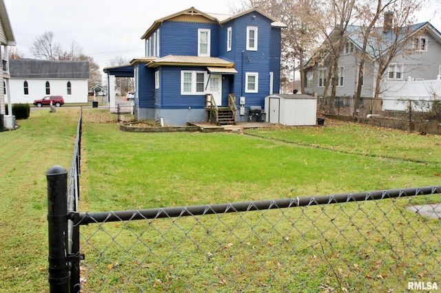 rear view of house with a yard, central AC, and a storage unit