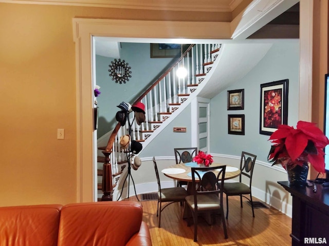 dining area featuring hardwood / wood-style floors and crown molding