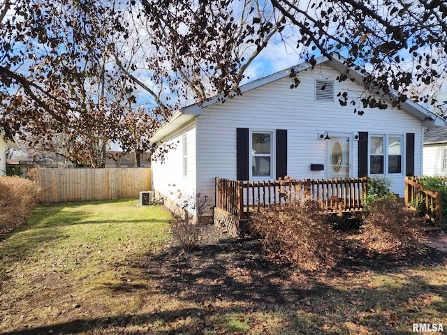 rear view of property with a yard, central AC, and a wooden deck