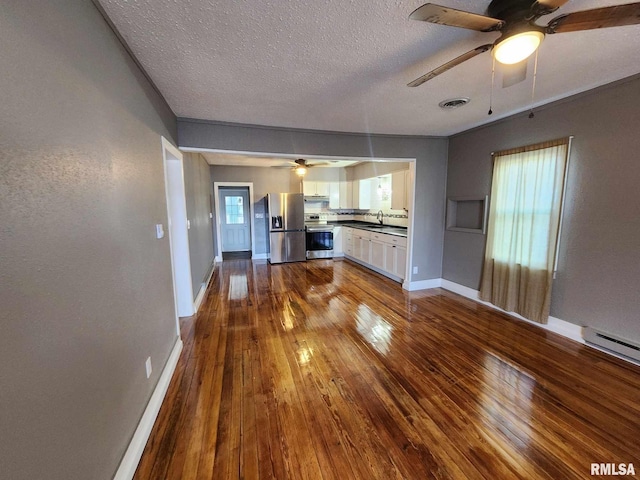 unfurnished living room with a textured ceiling, ceiling fan, baseboard heating, sink, and hardwood / wood-style floors