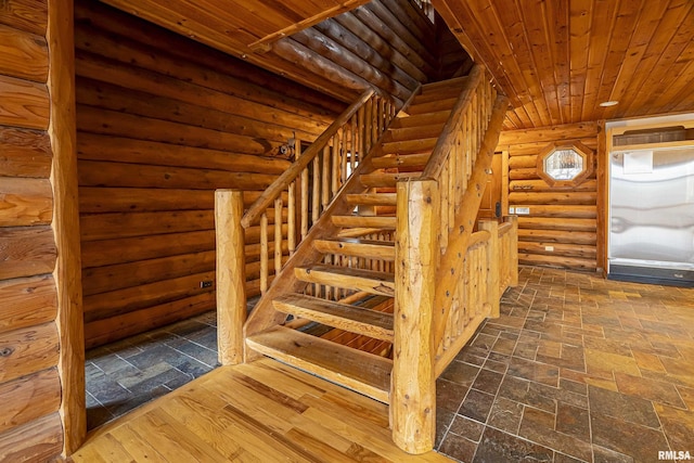 stairs with wooden ceiling and rustic walls