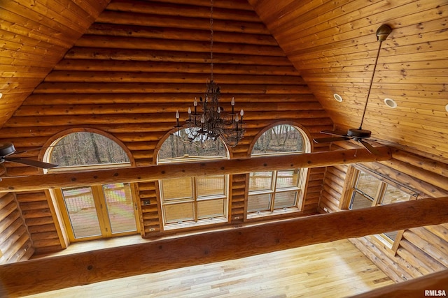 room details featuring log walls, ceiling fan with notable chandelier, and wooden ceiling