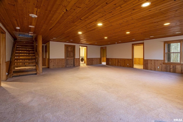 interior space featuring wooden walls, wooden ceiling, and carpet