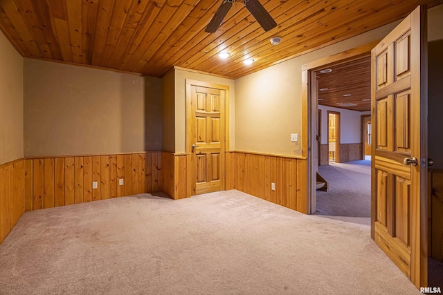 unfurnished room with wood ceiling, wooden walls, ceiling fan, and carpet flooring