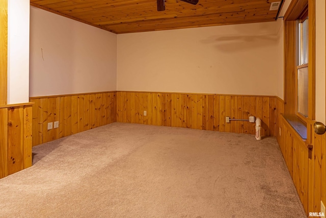 unfurnished room with carpet flooring, wood ceiling, and wood walls