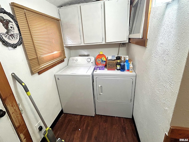 laundry room with washing machine and clothes dryer, dark hardwood / wood-style flooring, and cabinets