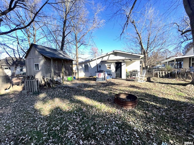 back of house with a storage unit