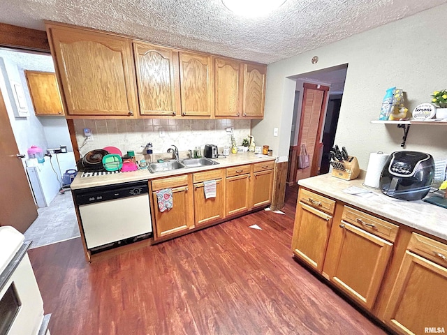 kitchen featuring backsplash, a textured ceiling, white dishwasher, sink, and dark hardwood / wood-style floors