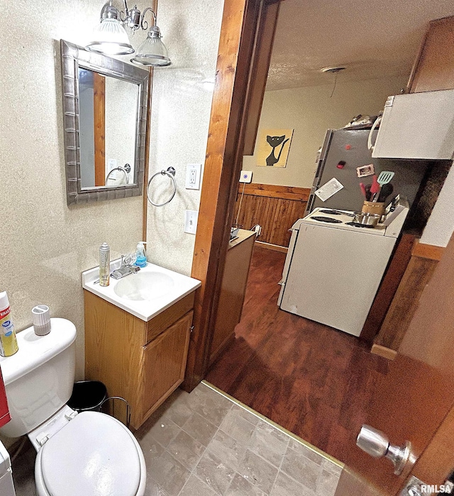 bathroom featuring hardwood / wood-style flooring, vanity, toilet, and wooden walls