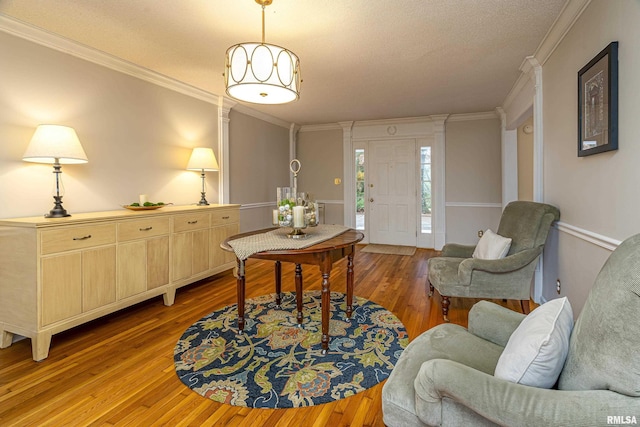 interior space featuring crown molding, a textured ceiling, and light wood-type flooring