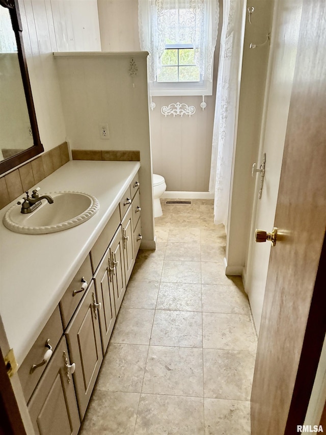 bathroom featuring tile patterned floors, vanity, and toilet