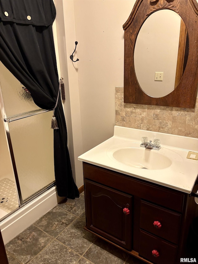 bathroom with tasteful backsplash, tile patterned flooring, vanity, and a shower with shower door