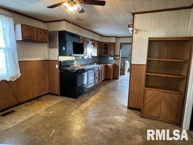 kitchen featuring stainless steel dishwasher, gas stove, ceiling fan, crown molding, and wood walls