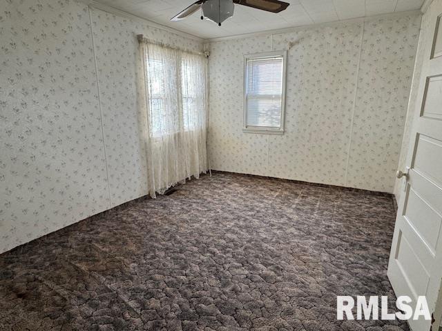 unfurnished room with carpet flooring, ceiling fan, and ornamental molding