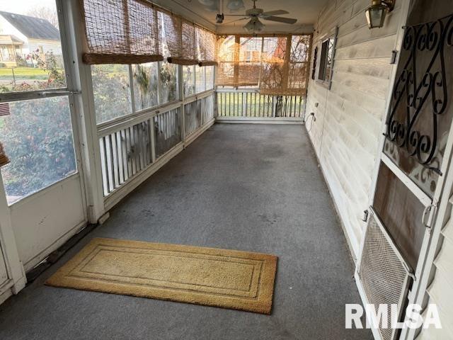 unfurnished sunroom with ceiling fan