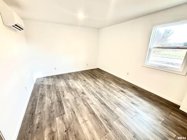 spare room with hardwood / wood-style flooring and a wall unit AC