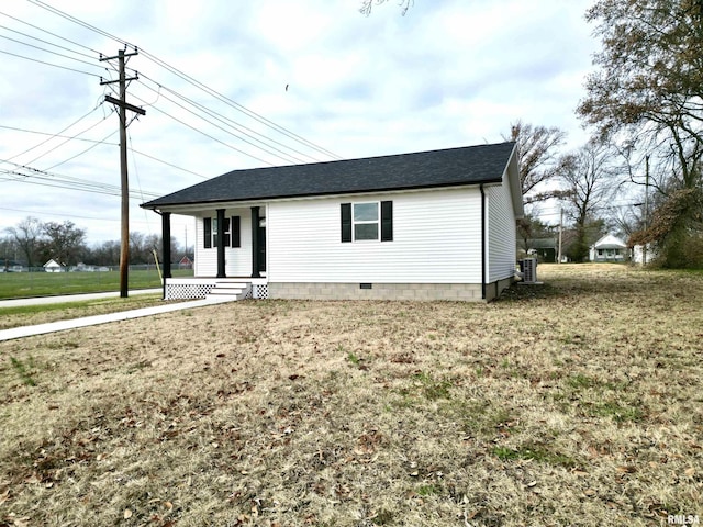 view of front of home featuring central AC, covered porch, and a front yard