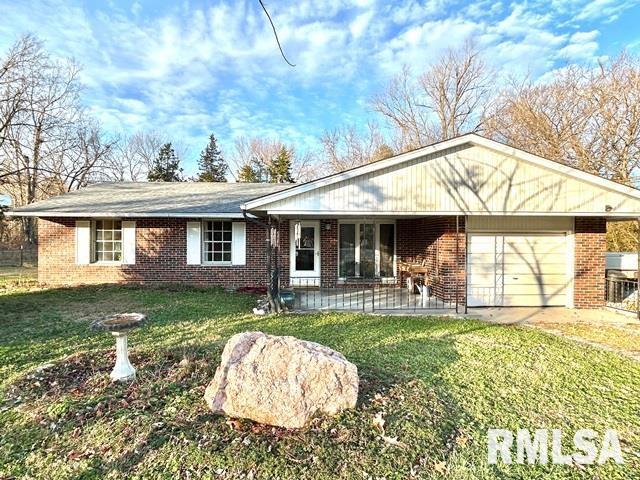 single story home with a front yard, a porch, and a garage