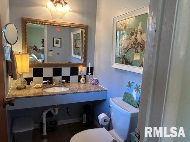 bathroom with backsplash, sink, and toilet