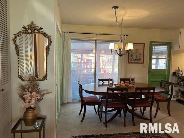 dining space with a notable chandelier and light carpet