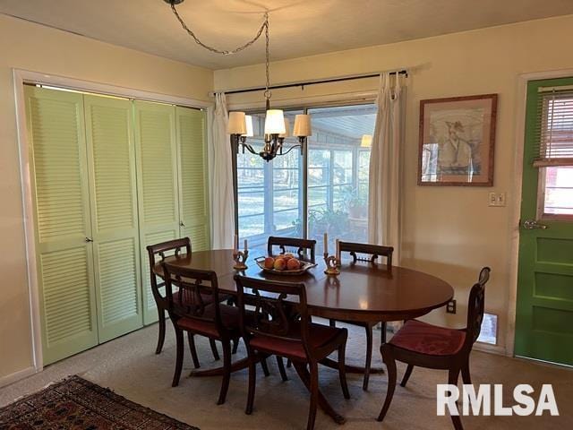 carpeted dining room with a chandelier