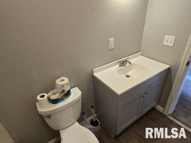 bathroom featuring vanity, hardwood / wood-style flooring, and toilet