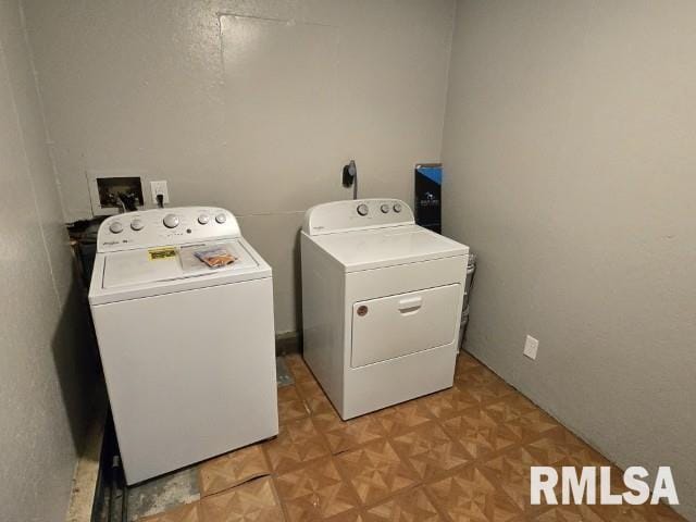 washroom with washer and clothes dryer and light parquet flooring