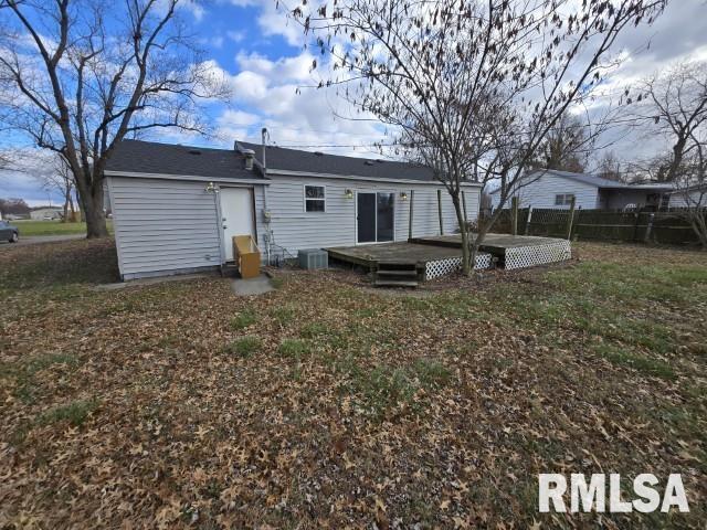 rear view of house with a lawn, central AC unit, and a deck