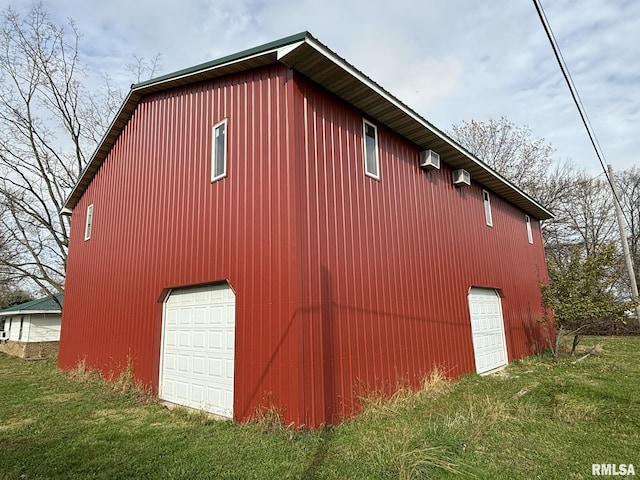 view of property exterior with a yard, a garage, an outdoor structure, and a wall unit AC