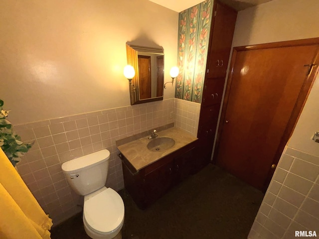 bathroom featuring toilet, tile walls, and sink