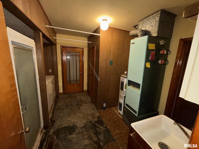 kitchen with wood walls, electric water heater, and sink