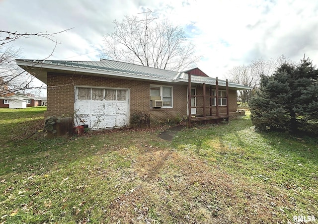 back of property with a garage, cooling unit, and a lawn