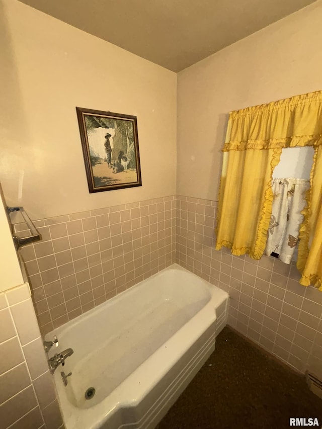 bathroom featuring a bath and tile walls