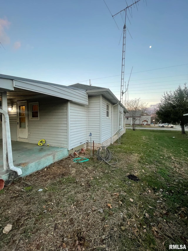 view of side of property with a patio area and a yard