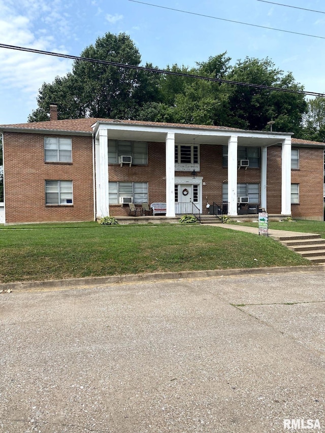 view of front of home with a front yard and cooling unit