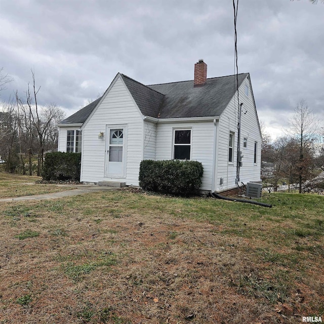 view of front of home with central AC unit and a front lawn