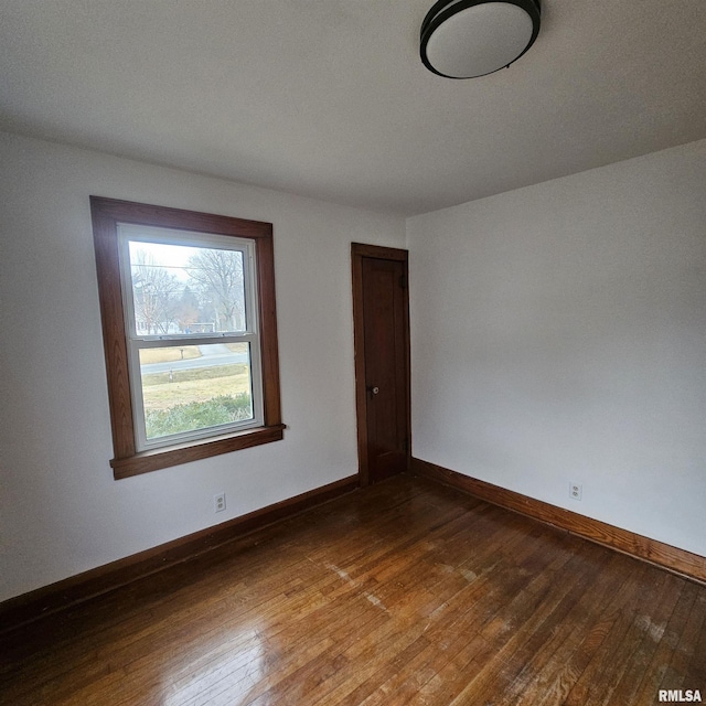 unfurnished room with dark hardwood / wood-style flooring