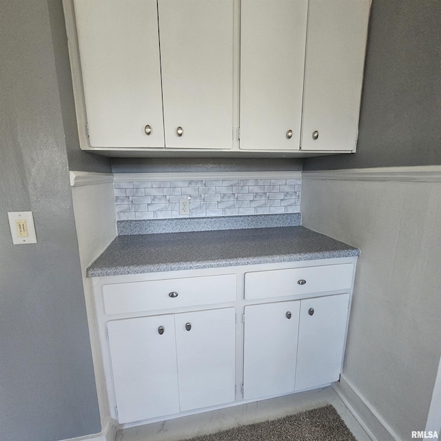 kitchen featuring tasteful backsplash and white cabinetry