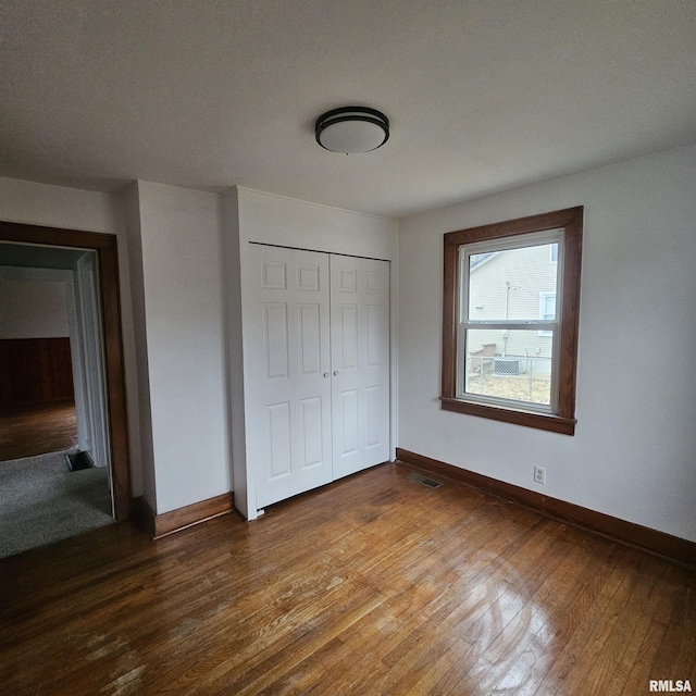 unfurnished bedroom with wood-type flooring and a closet