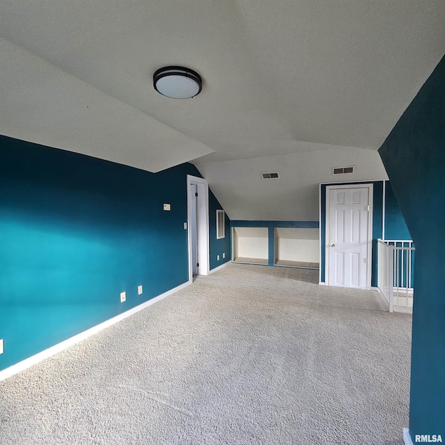 additional living space with carpet floors and vaulted ceiling